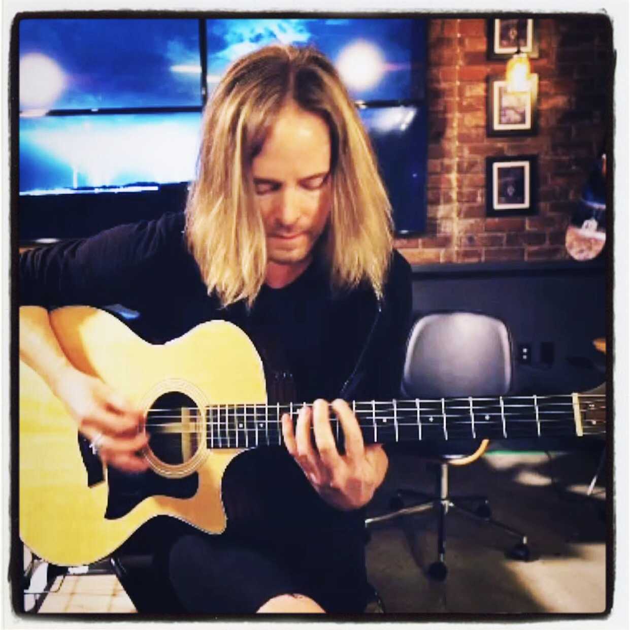 Micah Faulkner playing acoustic guitar in a studio